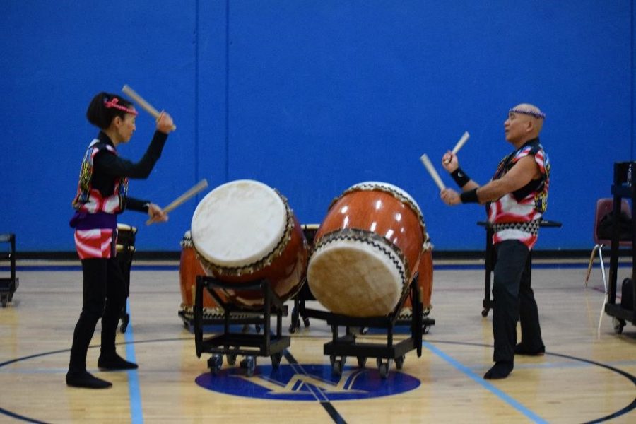 The performers playing the taikos (big drums).